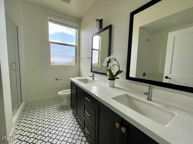 bathroom featuring tile patterned floors, vanity, toilet, and walk in shower