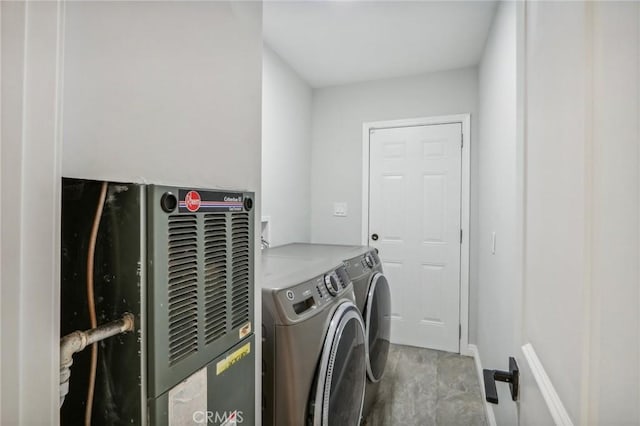 clothes washing area featuring heating unit and independent washer and dryer