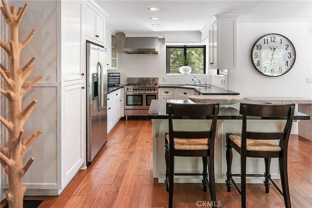 kitchen featuring white cabinets, appliances with stainless steel finishes, and a breakfast bar