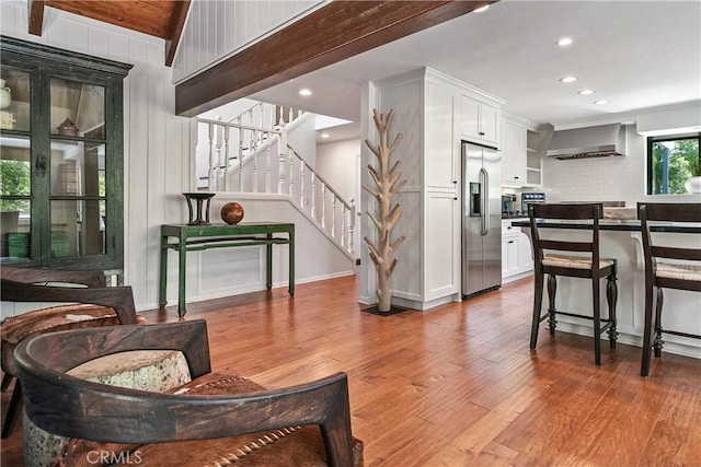 interior space with lofted ceiling with beams, hardwood / wood-style flooring, and wood walls