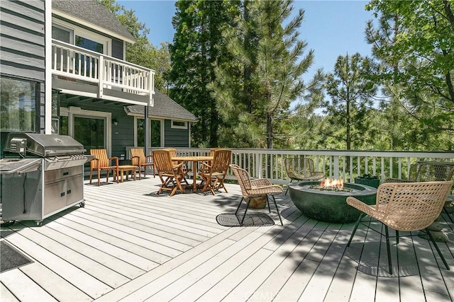 deck featuring an outdoor fire pit and a grill