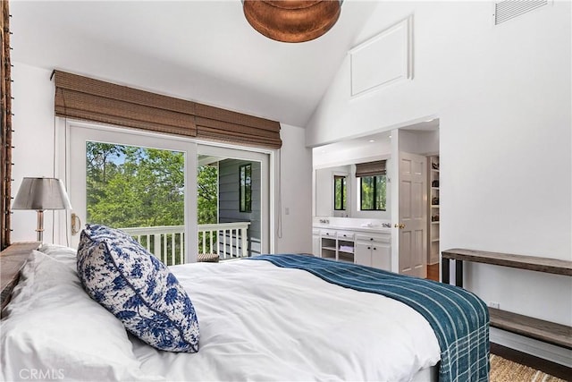 bedroom with hardwood / wood-style floors, ensuite bath, high vaulted ceiling, and multiple windows