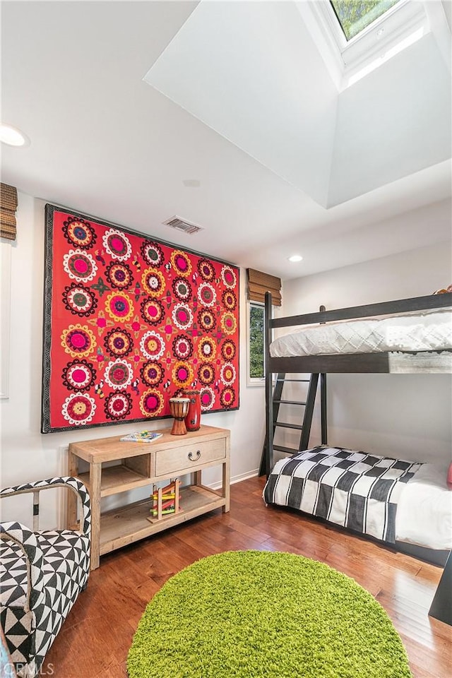 bedroom featuring a skylight and dark wood-type flooring