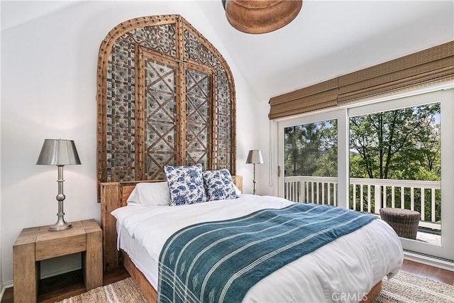 bedroom with hardwood / wood-style floors, lofted ceiling, and multiple windows