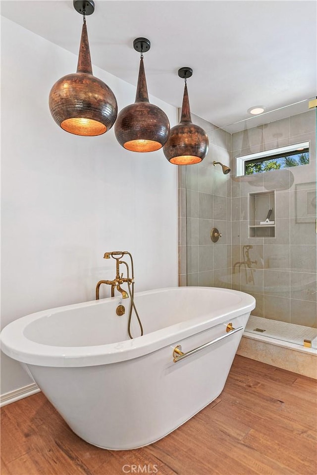 bathroom featuring wood-type flooring and shower with separate bathtub