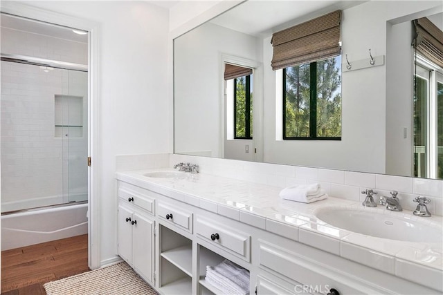 bathroom featuring combined bath / shower with glass door, hardwood / wood-style floors, and vanity