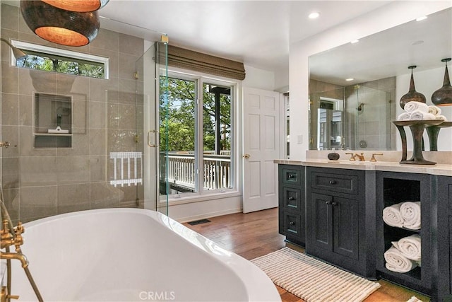 bathroom with vanity, a healthy amount of sunlight, wood-type flooring, and separate shower and tub