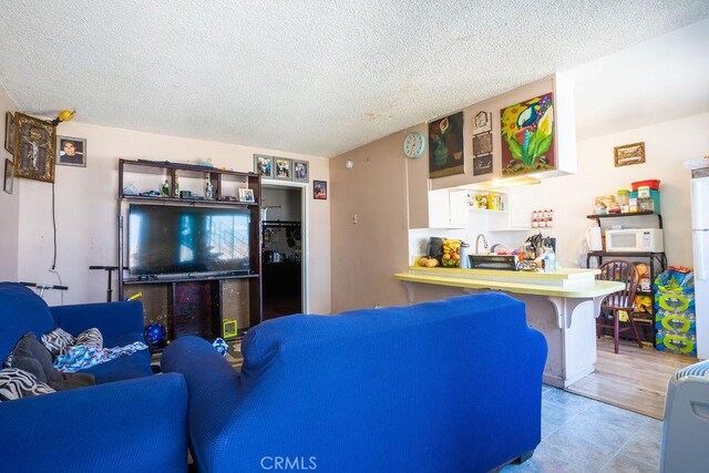 living room with a textured ceiling and light tile floors