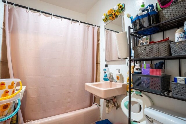 bathroom with shower / tub combo with curtain and toilet