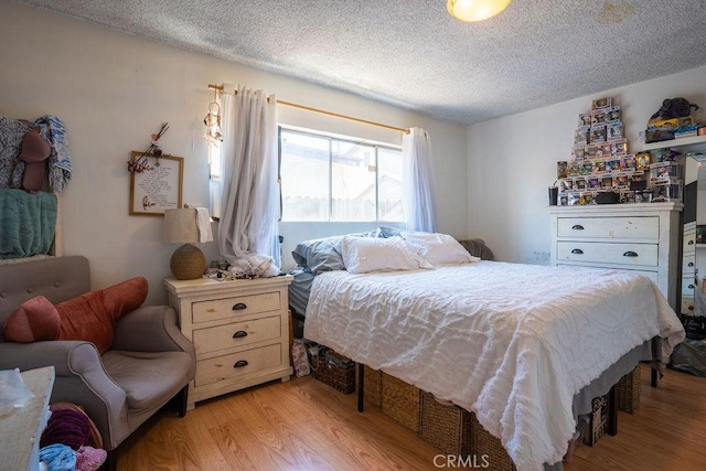 bedroom featuring a textured ceiling and light wood-type flooring