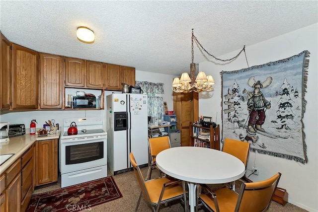 kitchen featuring hanging light fixtures, white appliances, a chandelier, and a textured ceiling