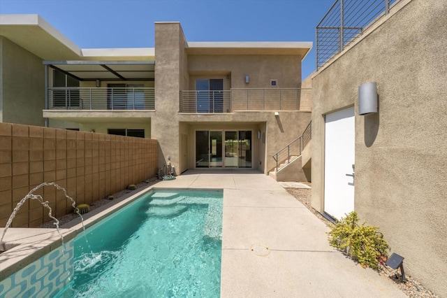 rear view of property with a fenced in pool