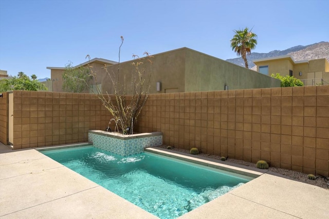 view of swimming pool with pool water feature and a mountain view