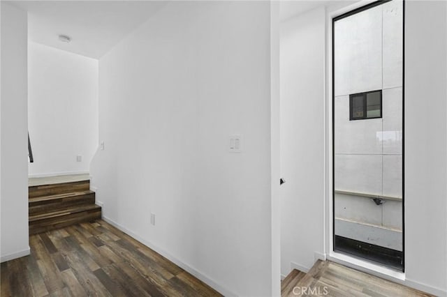 hallway with dark hardwood / wood-style flooring