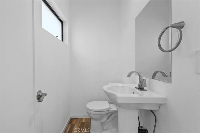 bathroom featuring wood-type flooring and toilet