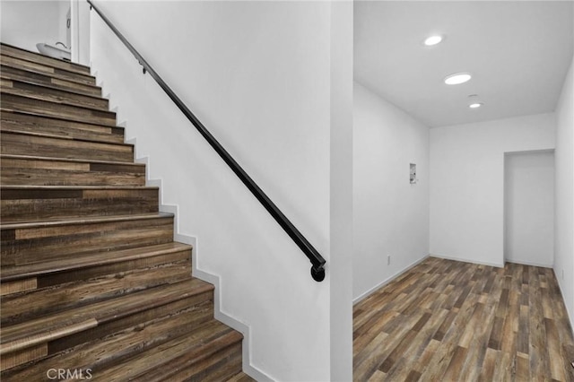 stairway with dark hardwood / wood-style flooring