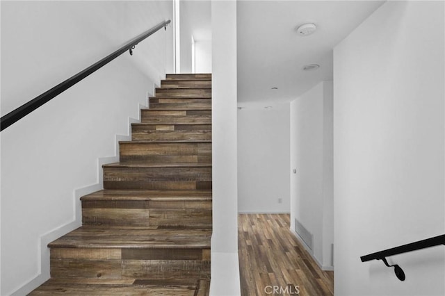 stairs featuring dark wood-type flooring