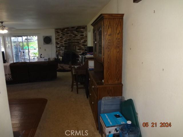 interior space with brick wall, ceiling fan, and a fireplace