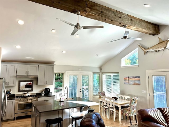 kitchen with gray cabinetry, stainless steel appliances, beamed ceiling, light hardwood / wood-style floors, and plenty of natural light