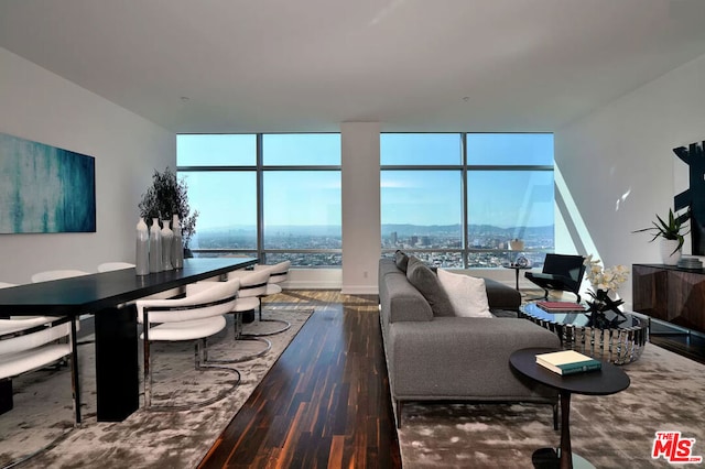 living room featuring dark wood-type flooring, a water view, and expansive windows