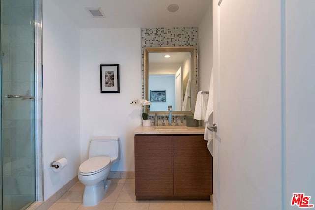 bathroom featuring toilet, vanity, walk in shower, and tile patterned flooring