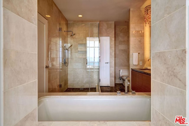 bathroom featuring toilet, tile walls, an enclosed shower, and vanity