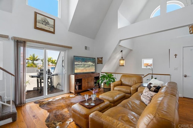 living room featuring high vaulted ceiling and wood-type flooring