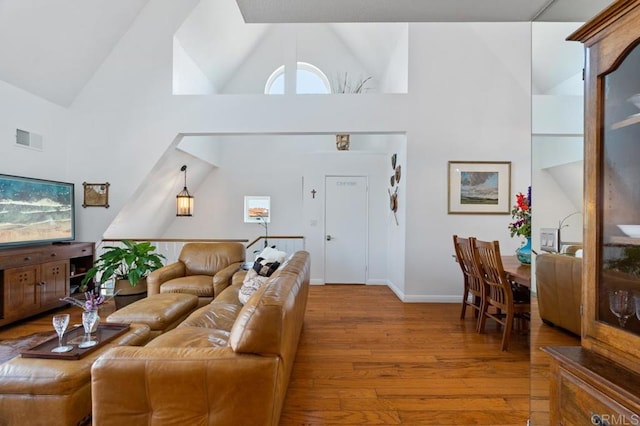 living room with high vaulted ceiling and hardwood / wood-style flooring