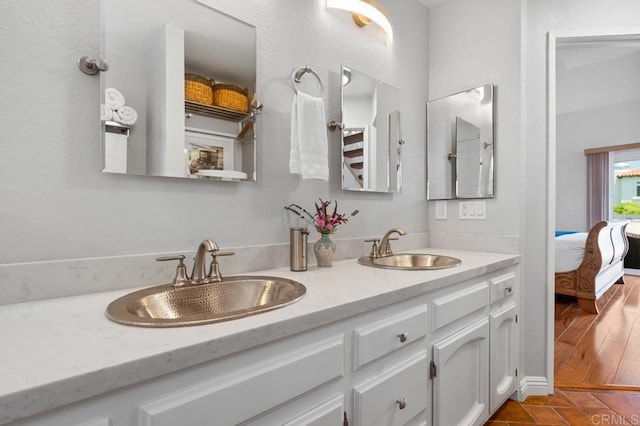 bathroom with large vanity, dual sinks, and hardwood / wood-style floors