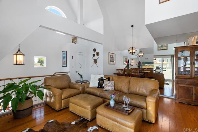 living room featuring high vaulted ceiling, a notable chandelier, and wood-type flooring