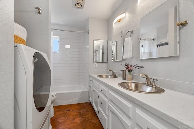 full bathroom with washer / dryer, oversized vanity, dual sinks, tiled shower / bath combo, and tile floors