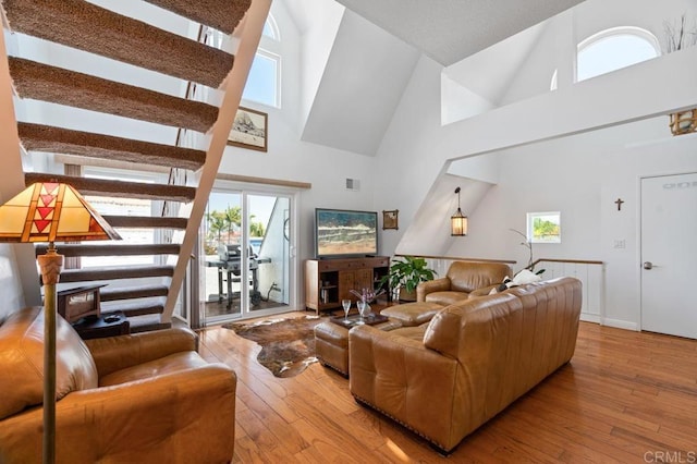 living room featuring a healthy amount of sunlight, a high ceiling, and hardwood / wood-style flooring