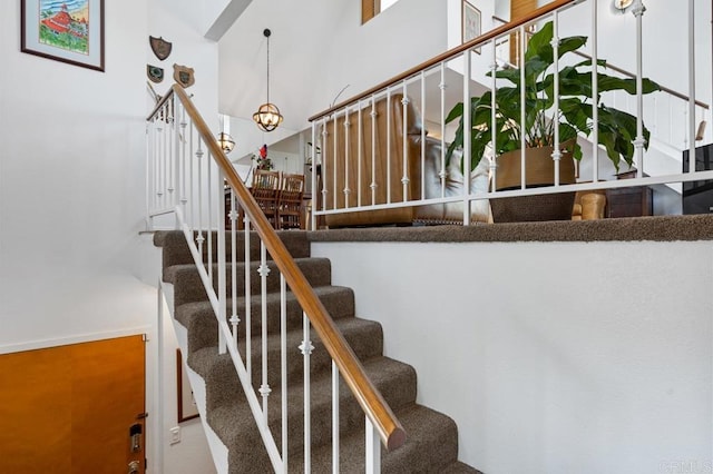 staircase featuring carpet and a high ceiling