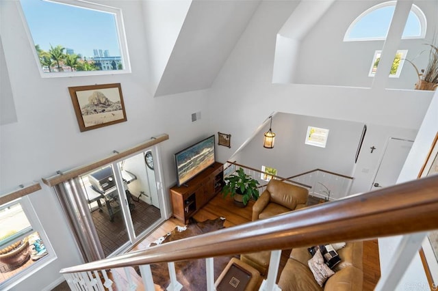 stairs featuring a towering ceiling and wood-type flooring