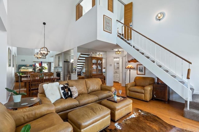 living room with a towering ceiling, hardwood / wood-style floors, and a chandelier