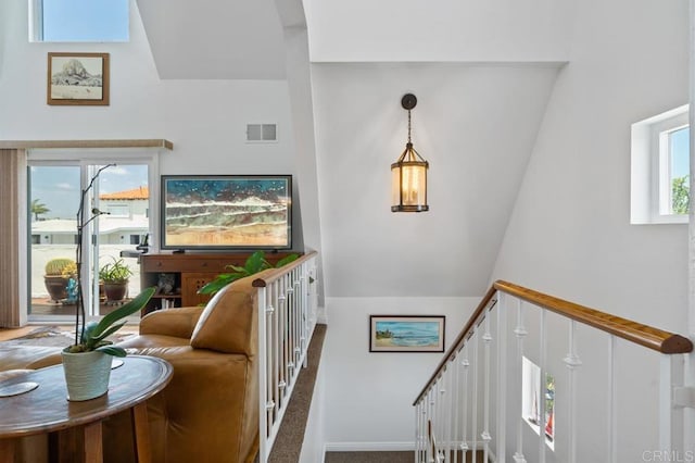 stairs featuring a high ceiling, plenty of natural light, and carpet