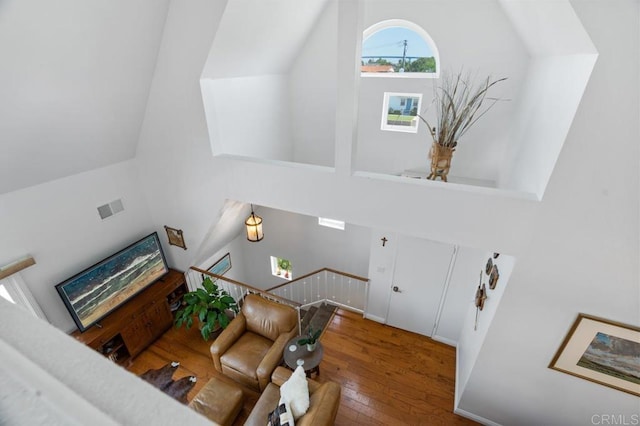 interior space featuring a towering ceiling and hardwood / wood-style flooring