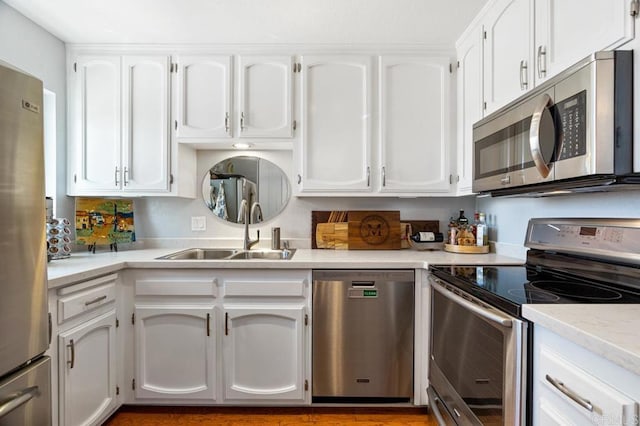 kitchen with stainless steel appliances, white cabinets, and sink