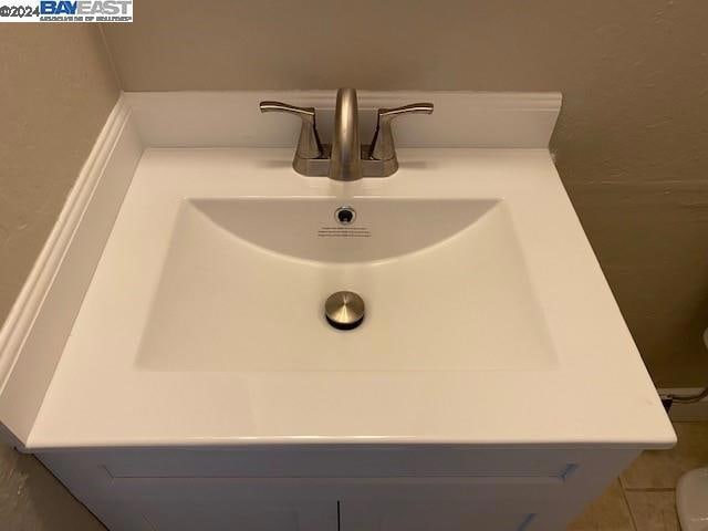 interior details featuring tile flooring, vanity, and toilet