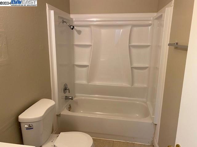 bathroom with tile floors, toilet, and bathtub / shower combination