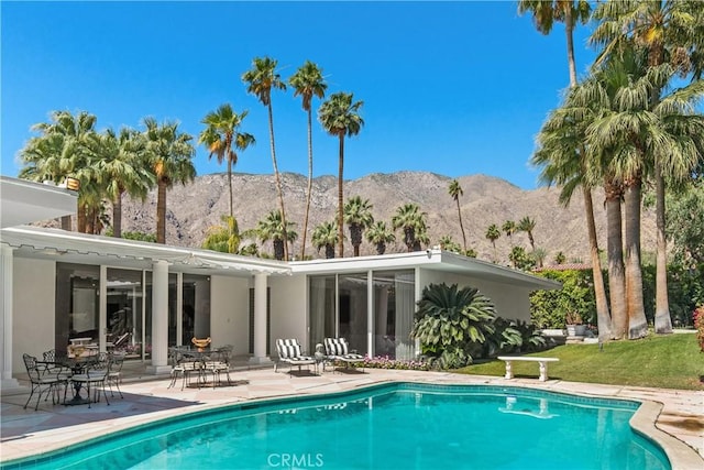 back of house featuring an outdoor pool, a mountain view, and a patio area