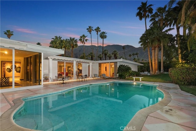 outdoor pool featuring a mountain view, a pergola, and a patio area