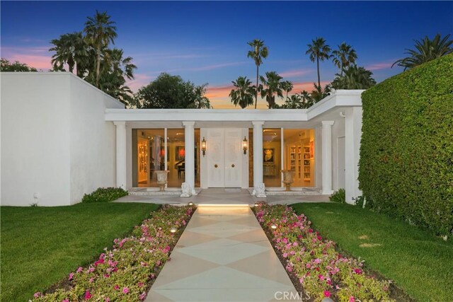 exterior entry at dusk with a lawn