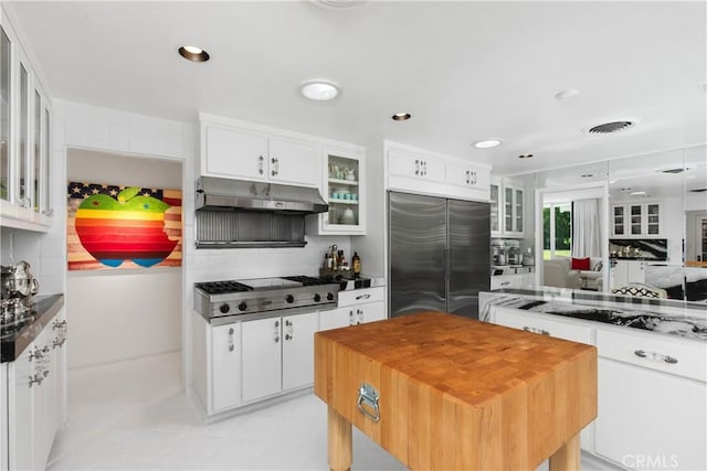 kitchen with visible vents, under cabinet range hood, decorative backsplash, white cabinets, and stainless steel appliances