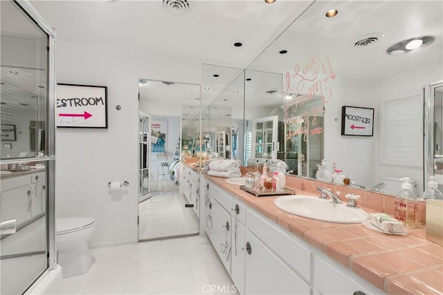 bathroom featuring visible vents, toilet, vanity, and baseboards