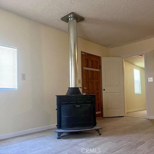 details with a wood stove, a textured ceiling, and hardwood / wood-style flooring