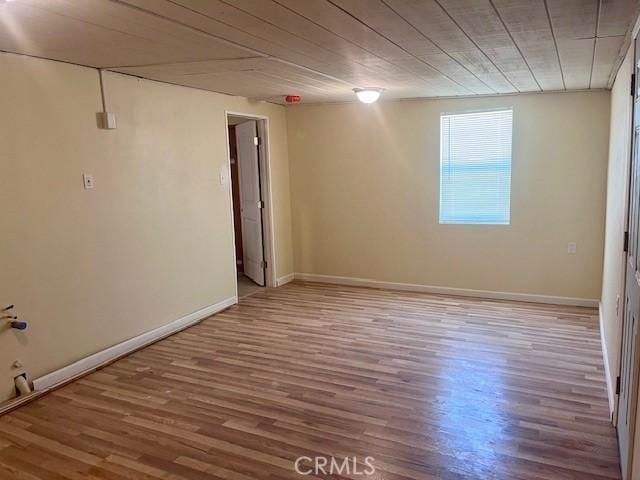 unfurnished room with hardwood / wood-style flooring and wood ceiling