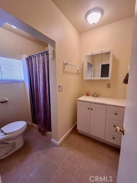 bathroom featuring tile patterned floors, vanity, toilet, and walk in shower