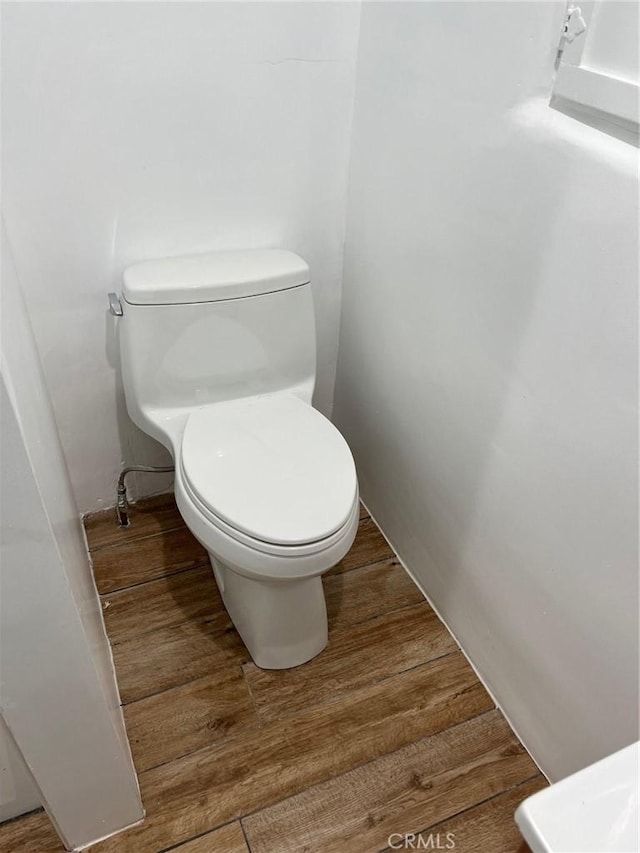 bathroom featuring wood-type flooring and toilet