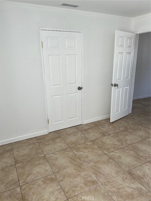 tiled empty room with crown molding